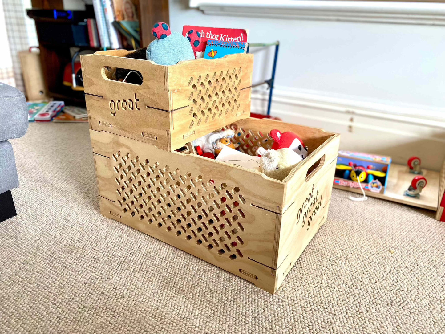 Wooden toy chest with toys on beige carpet in a lounge.