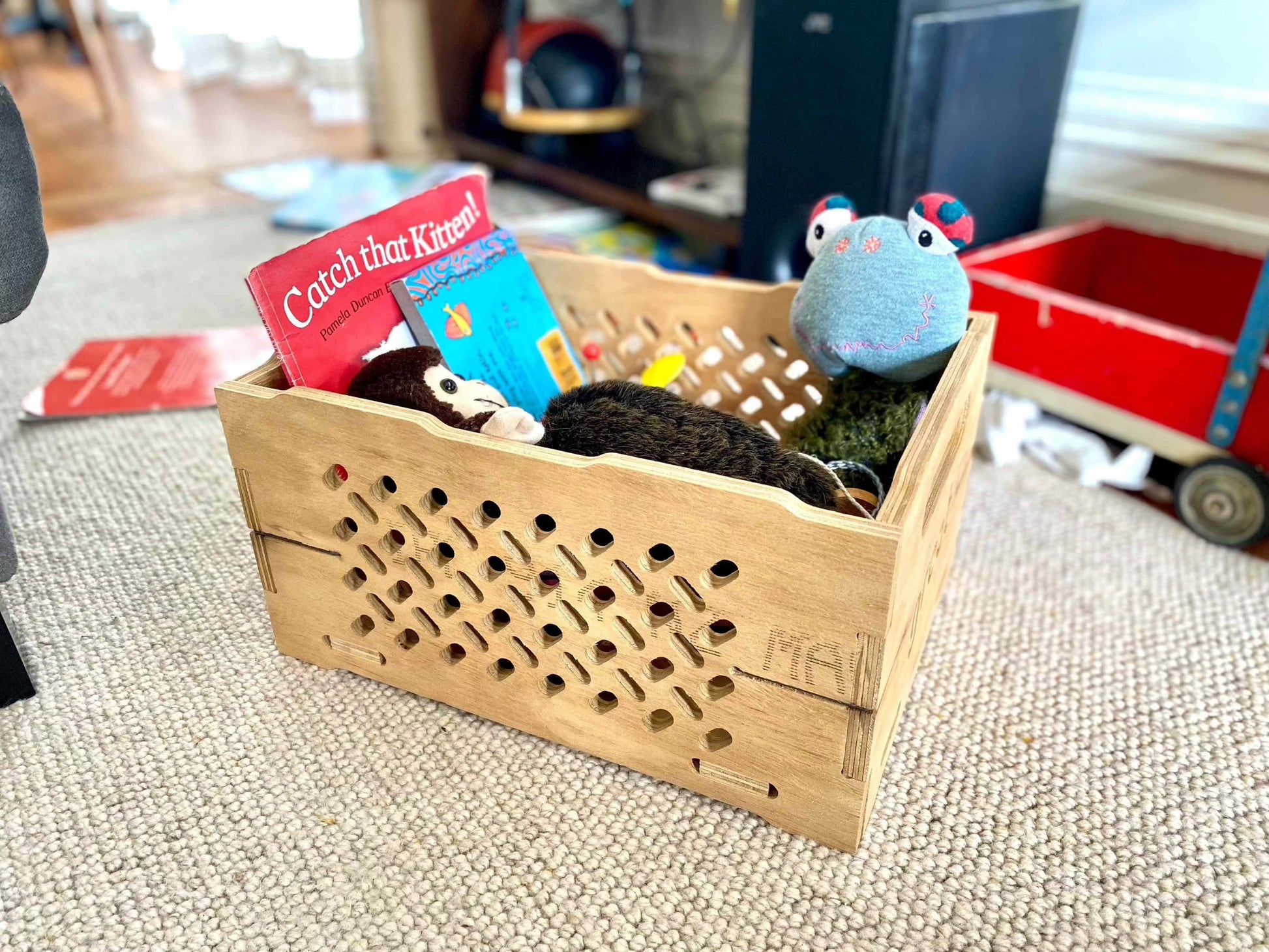 Wooden toy chest filled with plush toys and books, handcrafted from local materials.