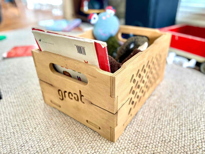 Wooden toy chest with books and toys, locally made with durable materials.