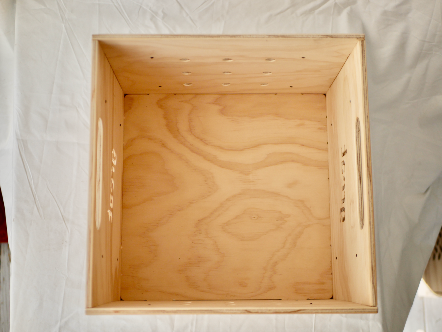 Wooden vinyl storage box with cut-out handles, designed for transporting records.