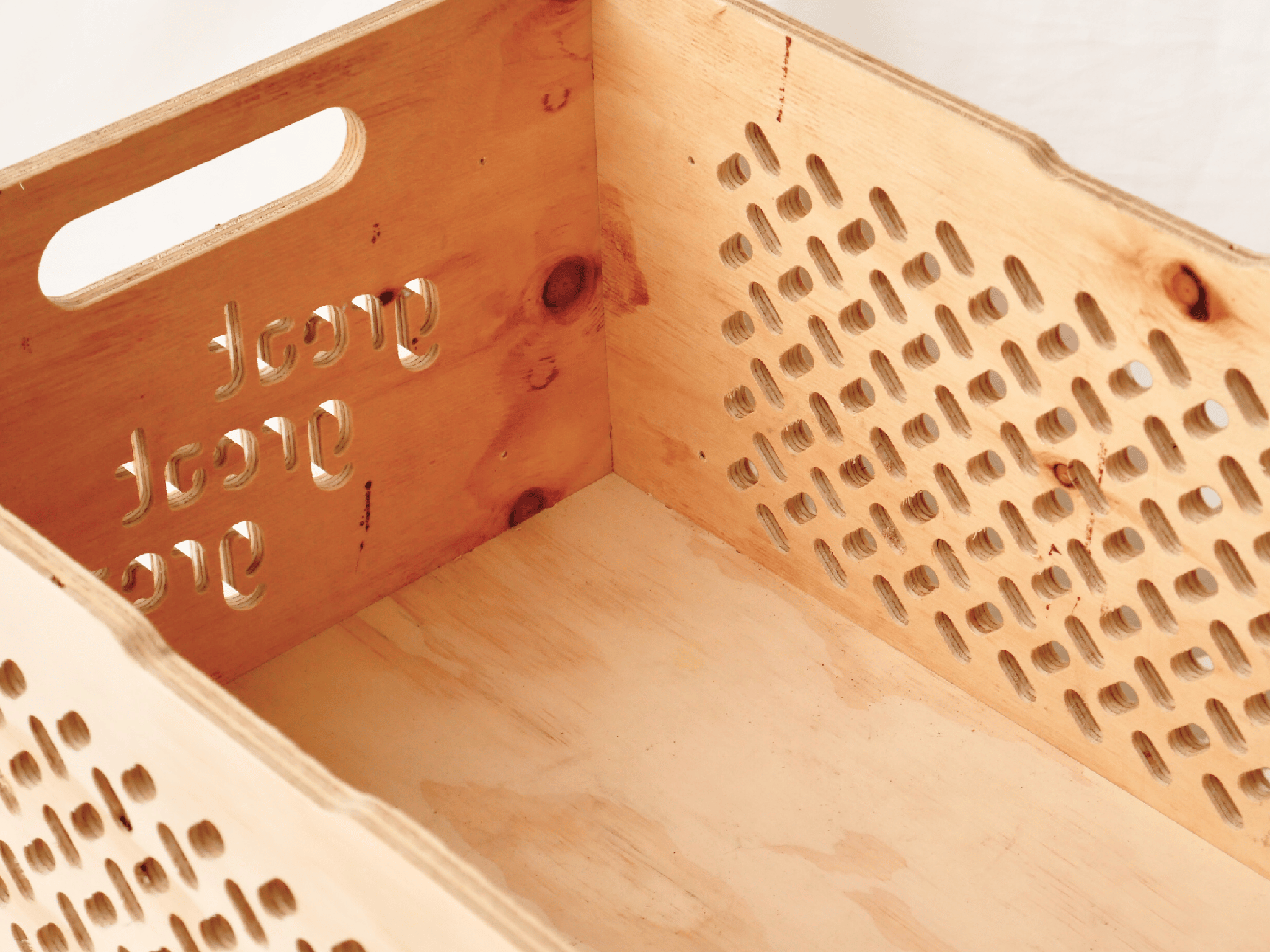 Wooden storage box with handle and perforated design, crafted from natural materials.